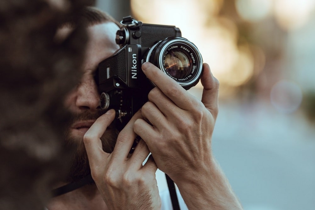 hombre fotografiando aves con una camara en el bosque